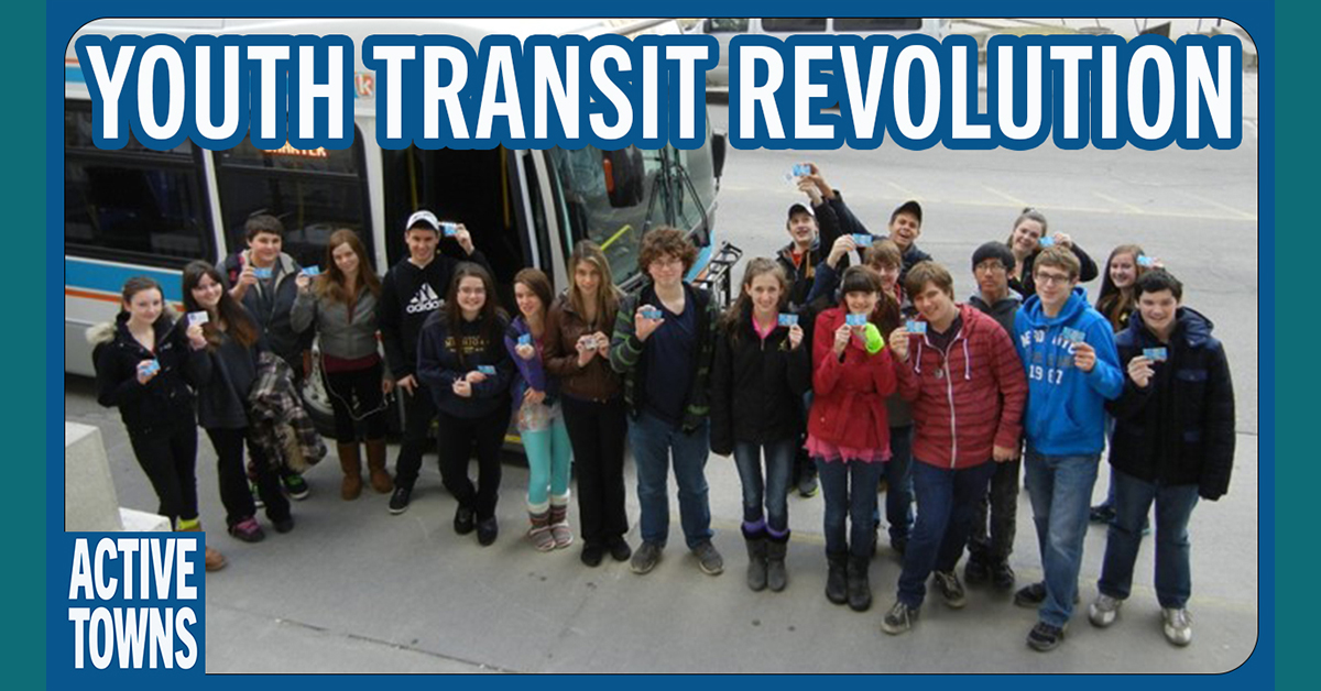 A group a kids standing in front of a bus holding up their transit passes